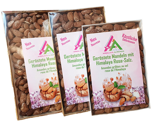 Trois bo&icirc;tes transparentes &agrave; fond dor&eacute; remplies d&#039;amandes, id&eacute;ales comme cadeaux